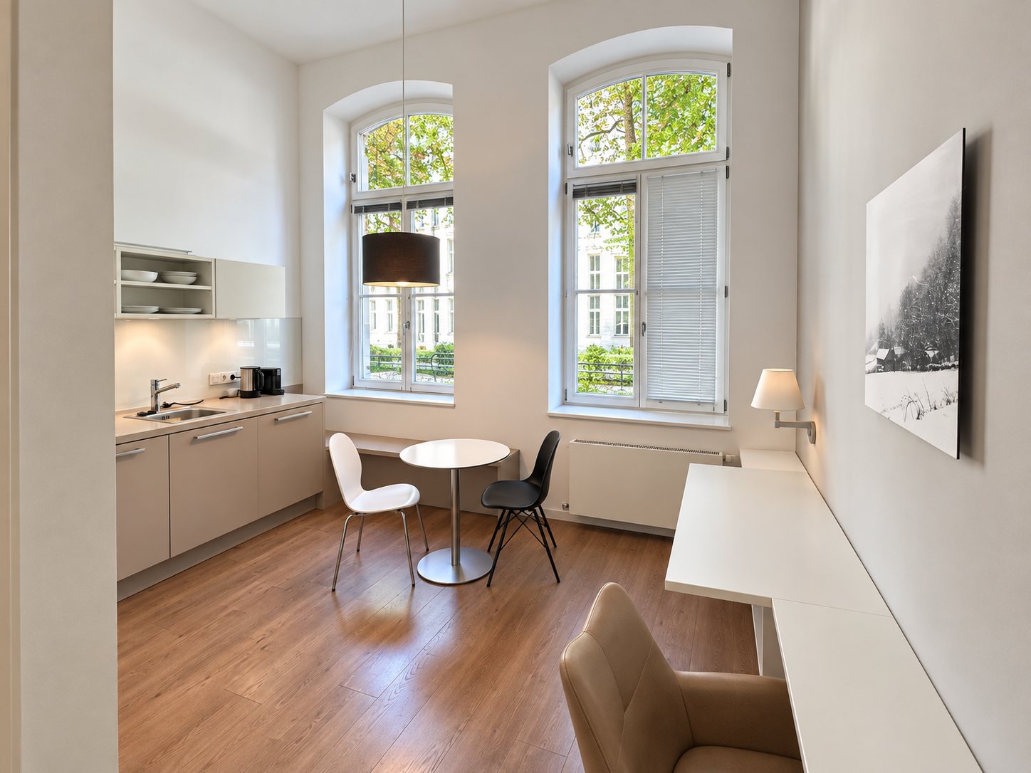 Apartment S im Erdgeschoss des Haupthauses: Wohnbereich mit Küchenzeile und Esstisch am Fenster