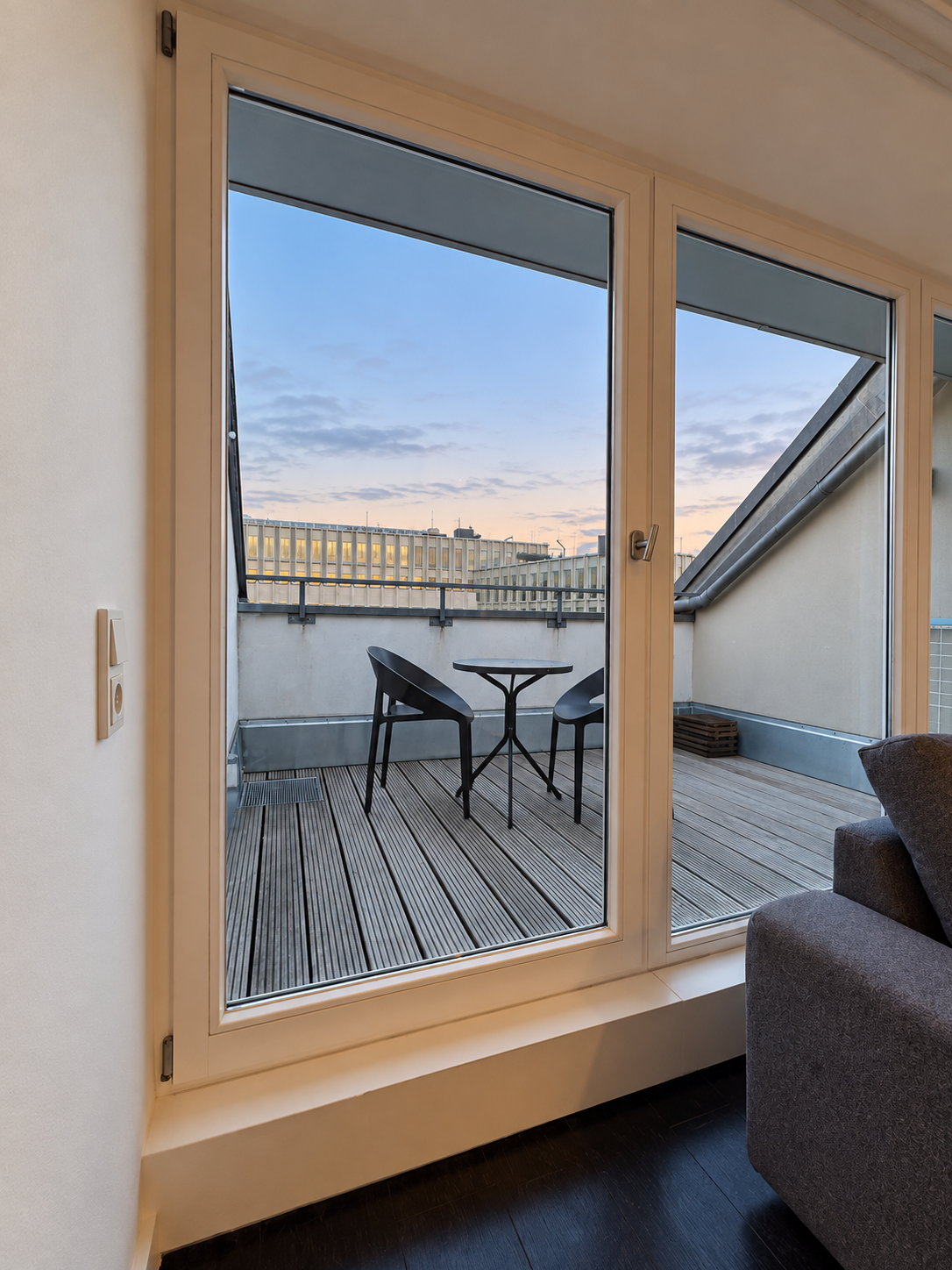 Dachgeschoss-Apartment: Blick auf die Terrasse mit Tisch und Stühlen
